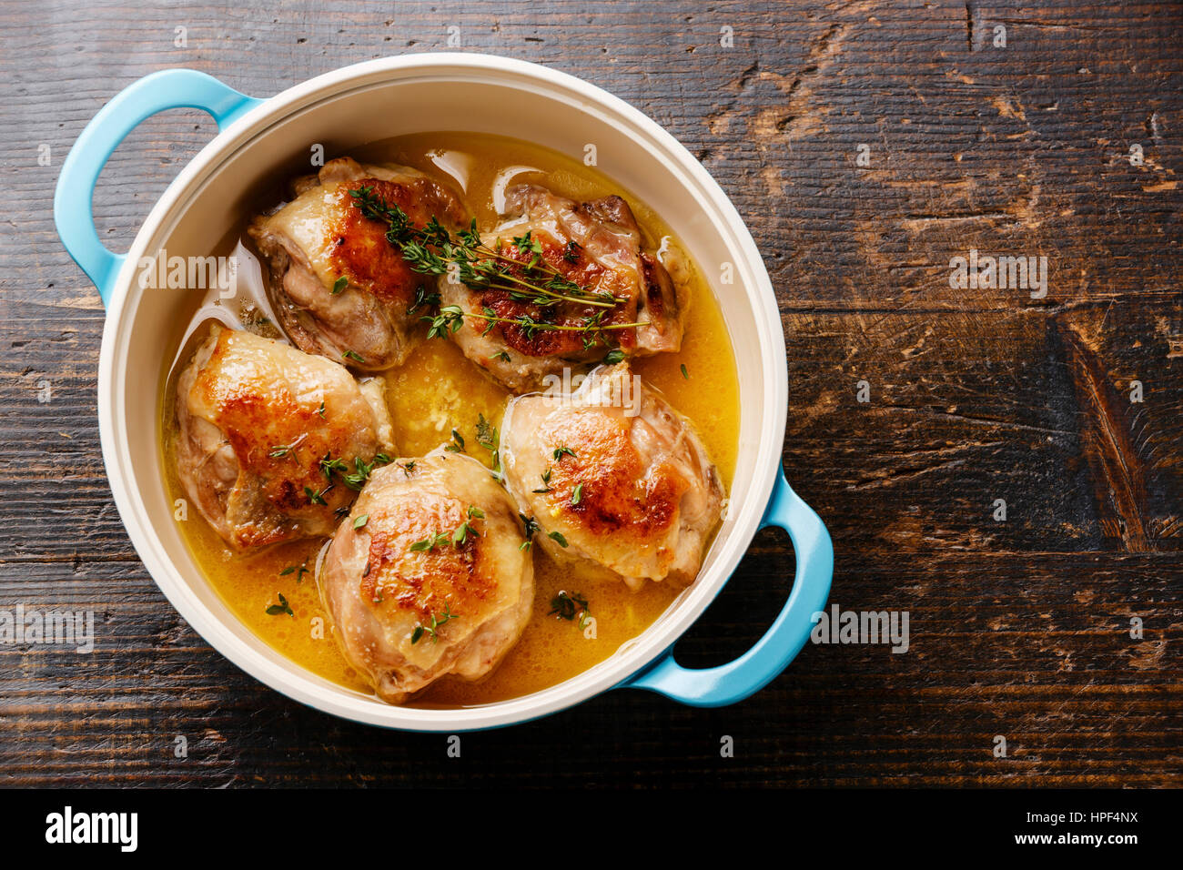 Roast chicken stew in cast iron pan on wooden background copy space Stock Photo