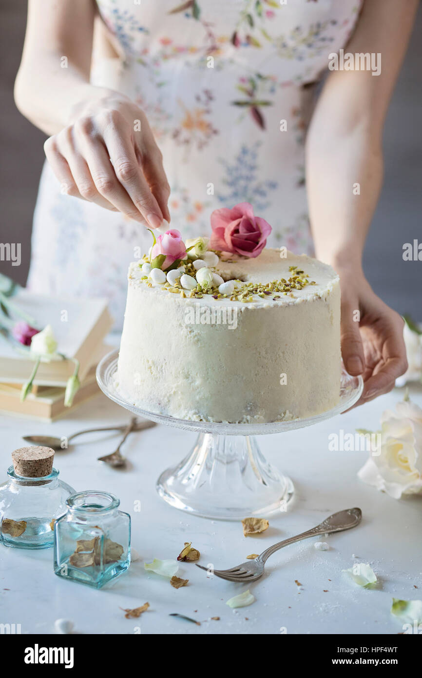 Woman is decorating a chiffon cake on marble table Stock Photo