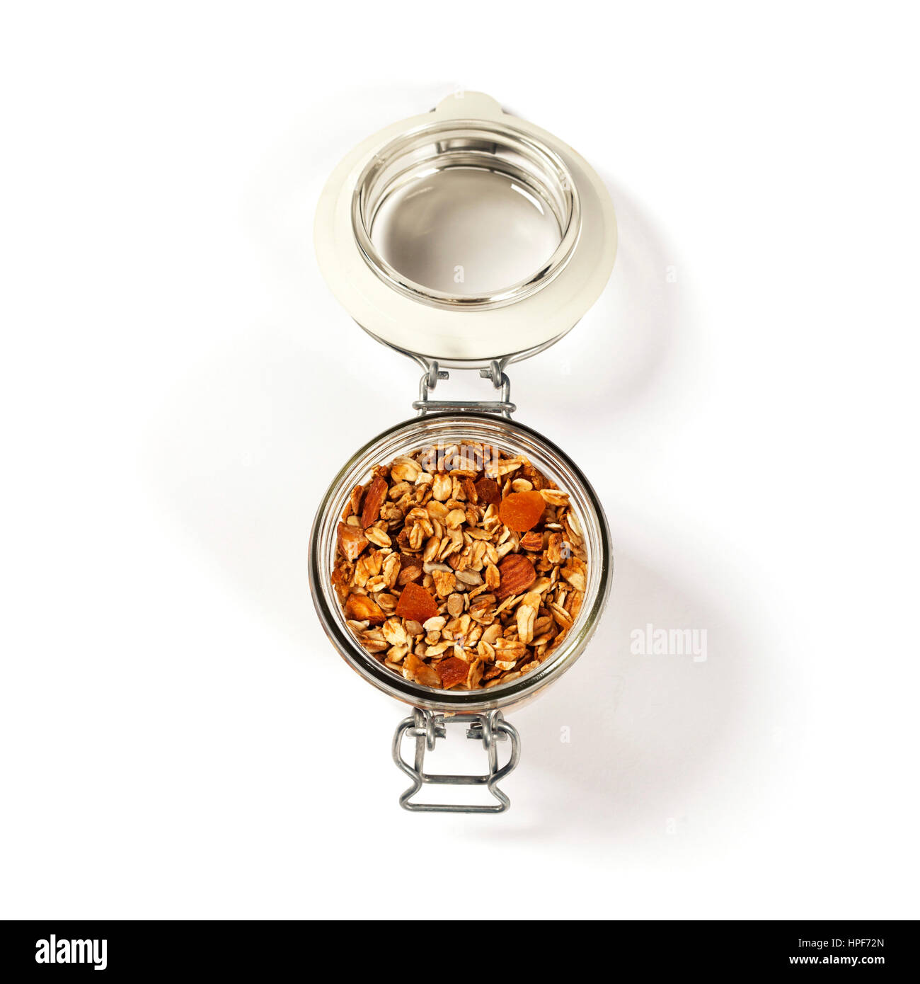 Homemade oatmeal granola with fruits and nuts in a glass jar on white background Stock Photo