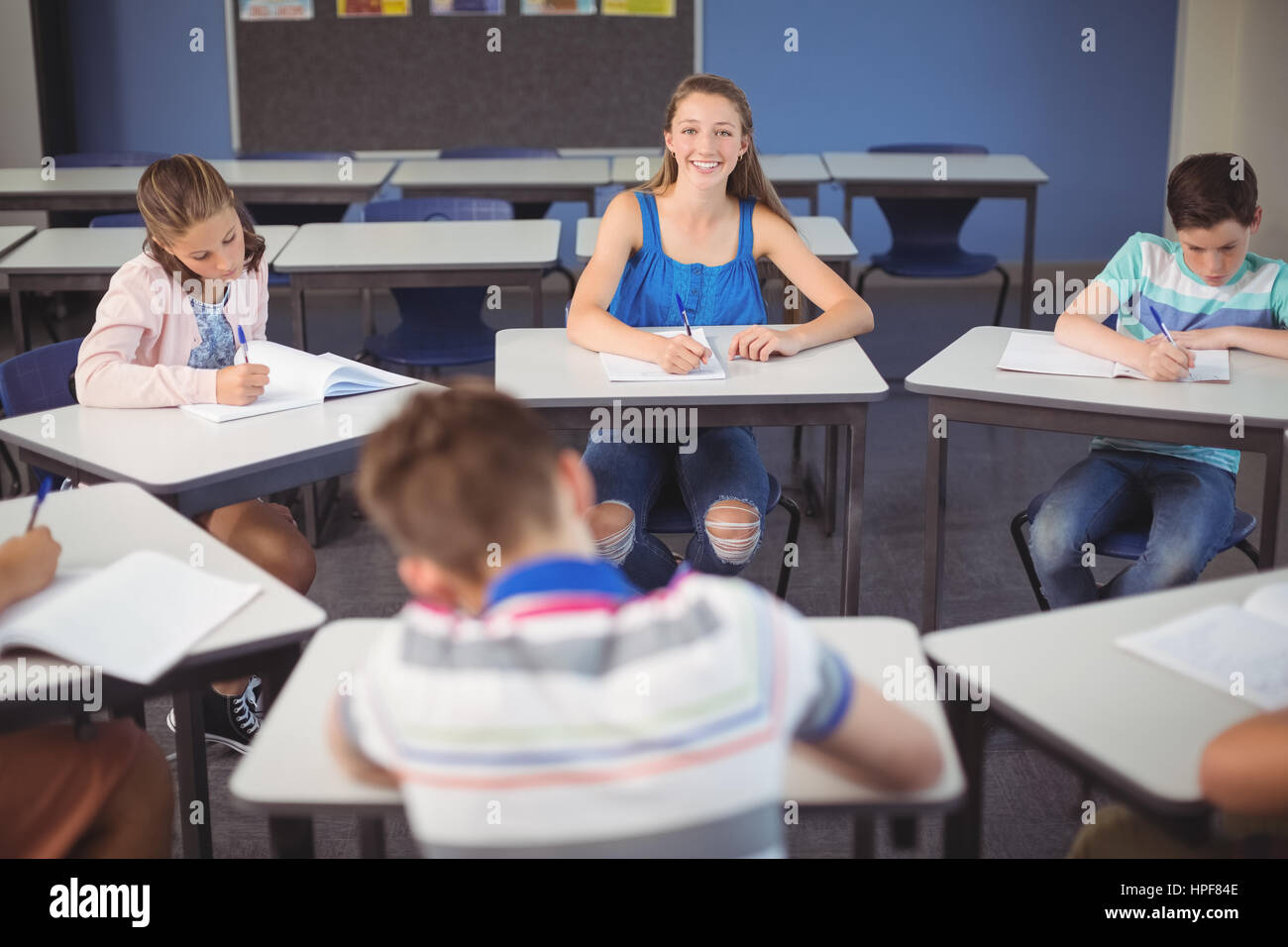 Portrait of schoolgirl sitting at desk in classroom Stock Photo - Alamy