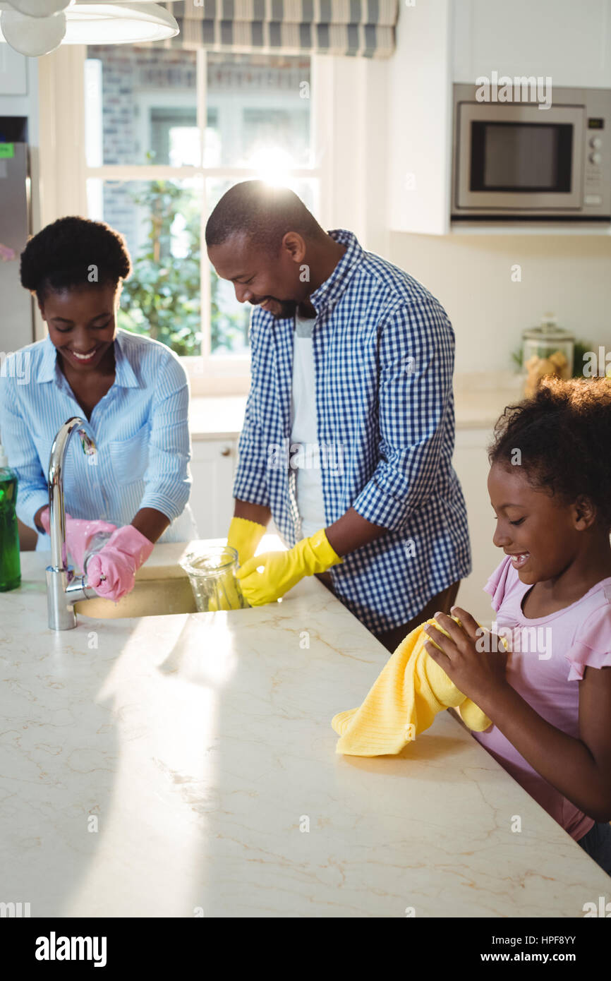 Family washing utensils in kitchen sink at home Stock Photo