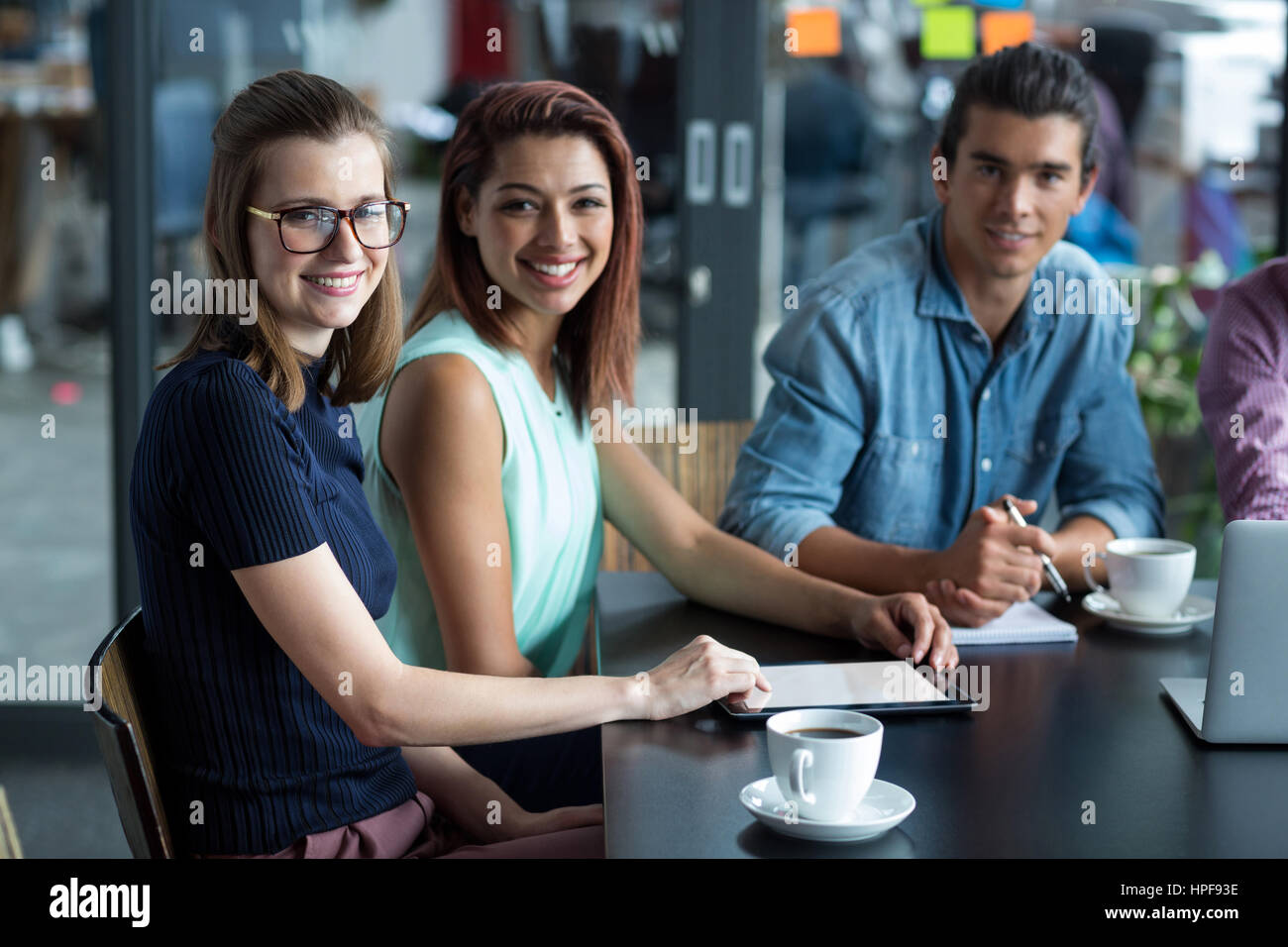 Portrait of smiling business executives sitting in office Stock Photo ...
