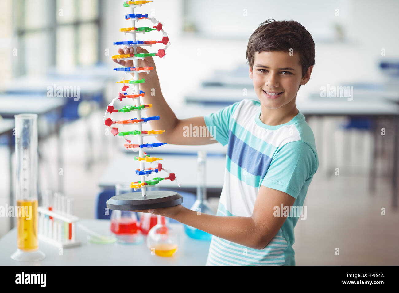 Portrait of schoolboy experimenting molecule model in laboratory at ...