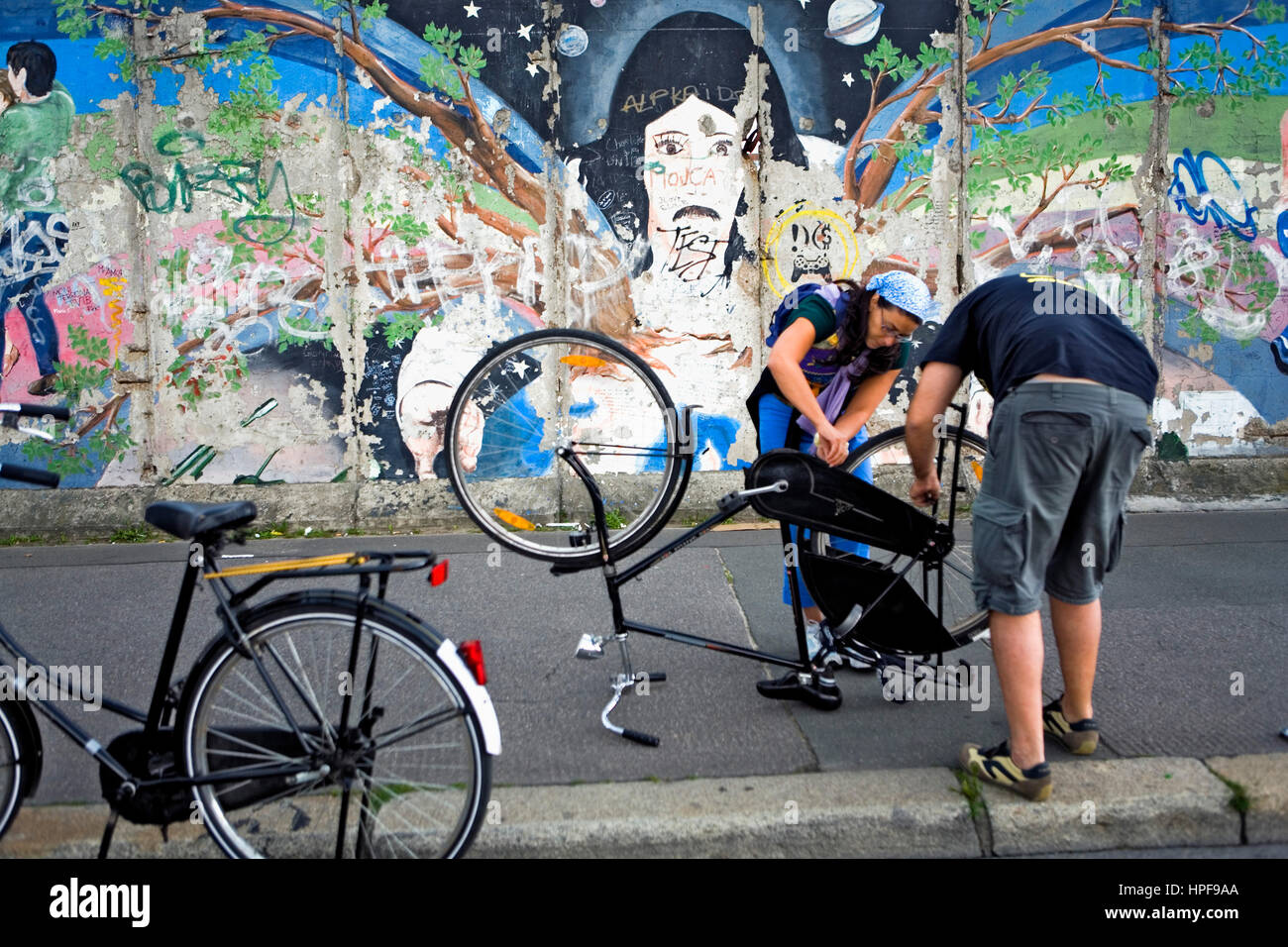 East Side Gallery. repairing the bicycle.Berlin. Germany Stock Photo