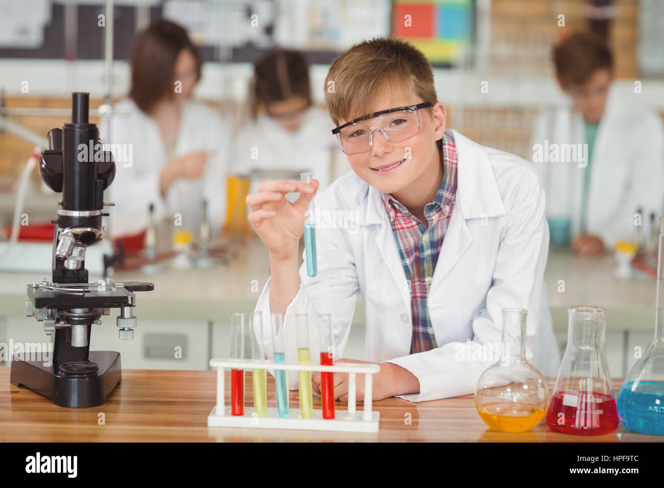 Portrait of schoolboy doing a chemical experiment in laboratory at ...