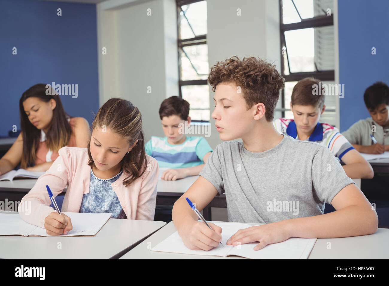 Attentive school kids doing homework in classroom at school Stock Photo ...