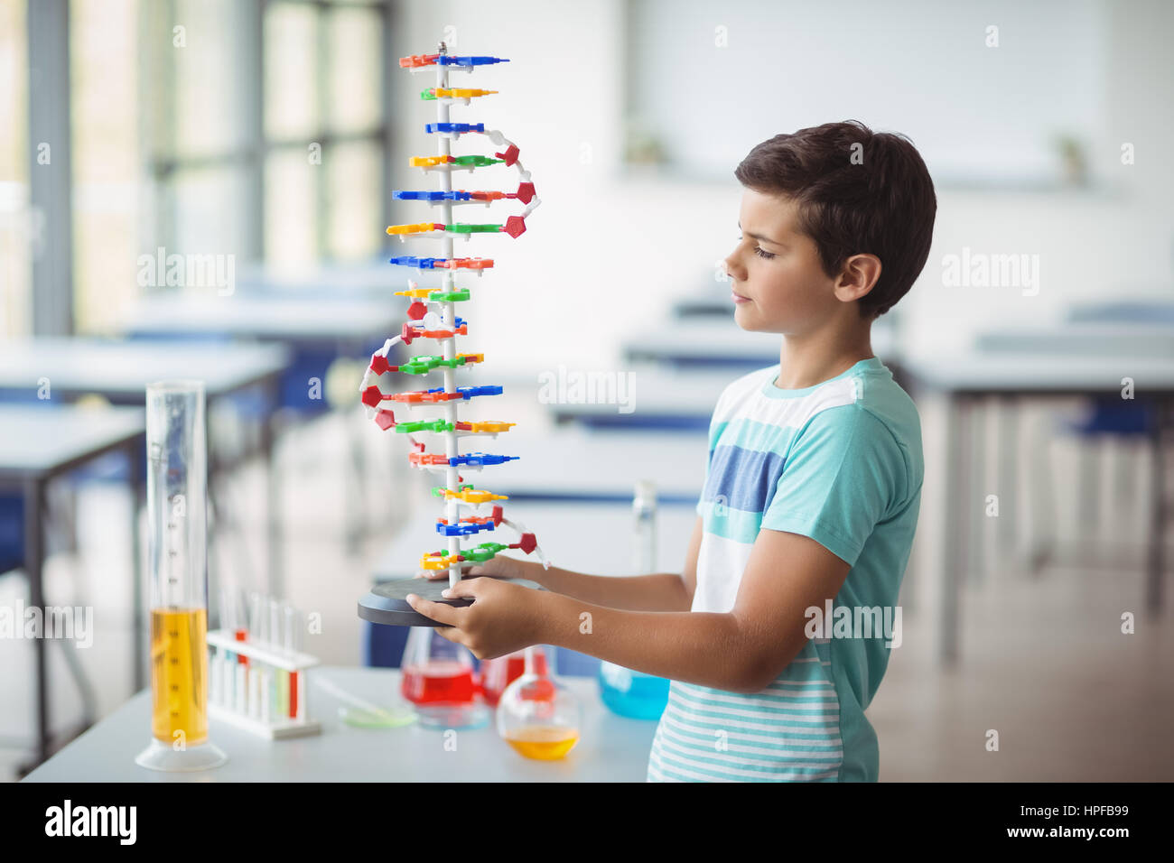 Attentive schoolboy experimenting molecule model in laboratory at ...