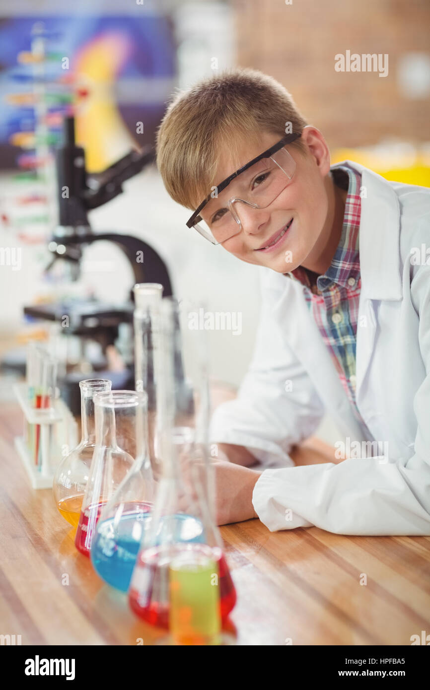 Portrait of schoolboy doing a chemical experiment in laboratory at ...