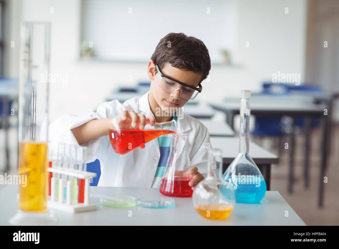 Attentive schoolboy doing a chemical experiment in laboratory at school ...