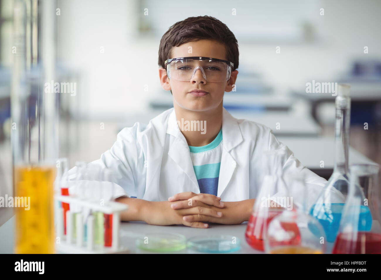 Portrait of schoolboy sitting in laboratory at school Stock Photo - Alamy