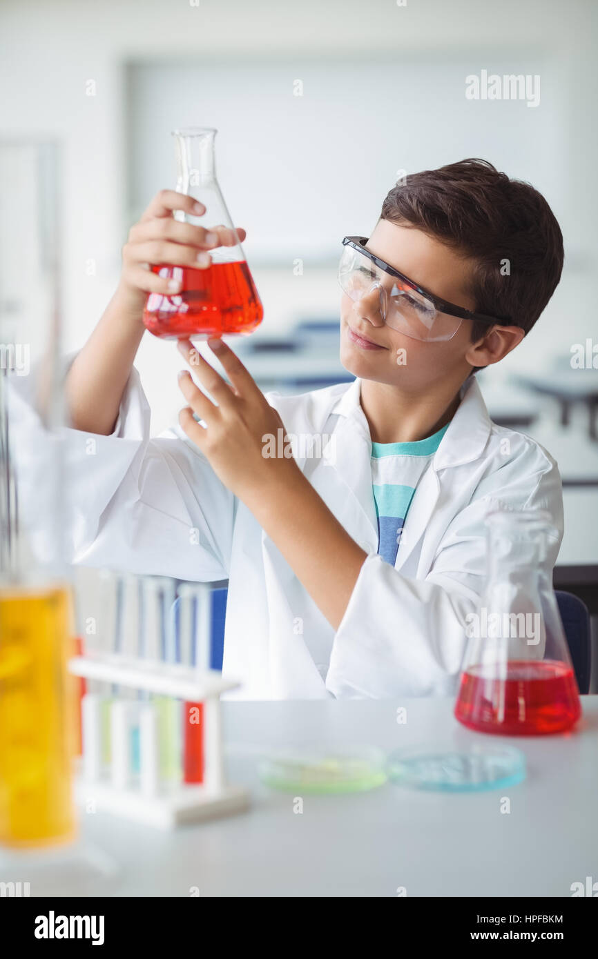 Attentive schoolboy doing a chemical experiment in laboratory at school ...