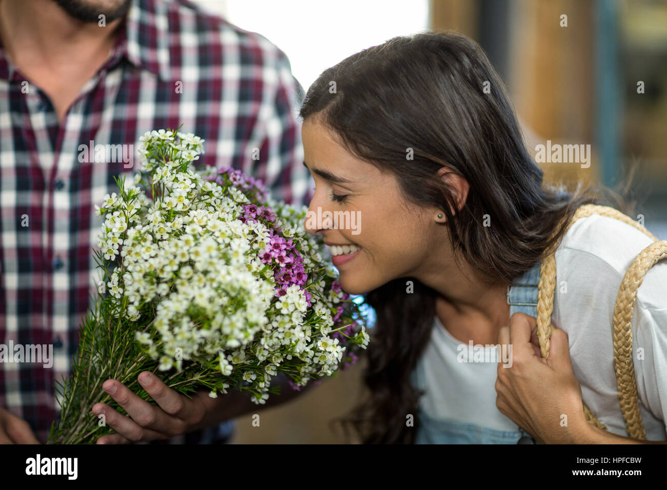 Couple smelling while selecting flowers at florist shop Stock Photo