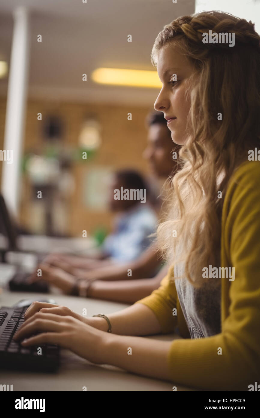 Smiling schoolgirl studying in computer classroom at school Stock Photo ...