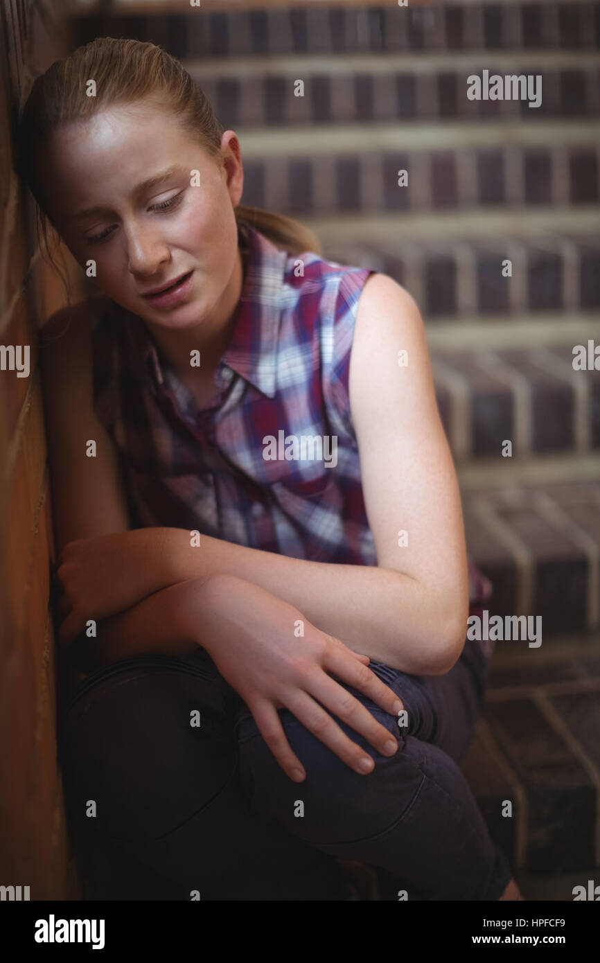 Sad schoolgirl sitting alone on staircase in school Stock Photo Alamy