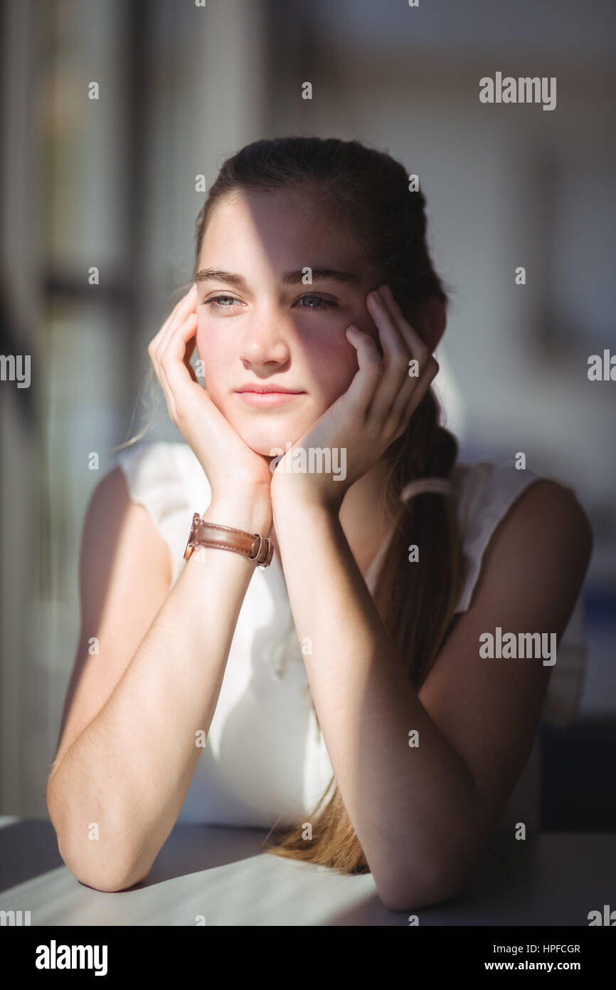 Thoughtful schoolgirl sitting in classroom at school Stock Photo - Alamy