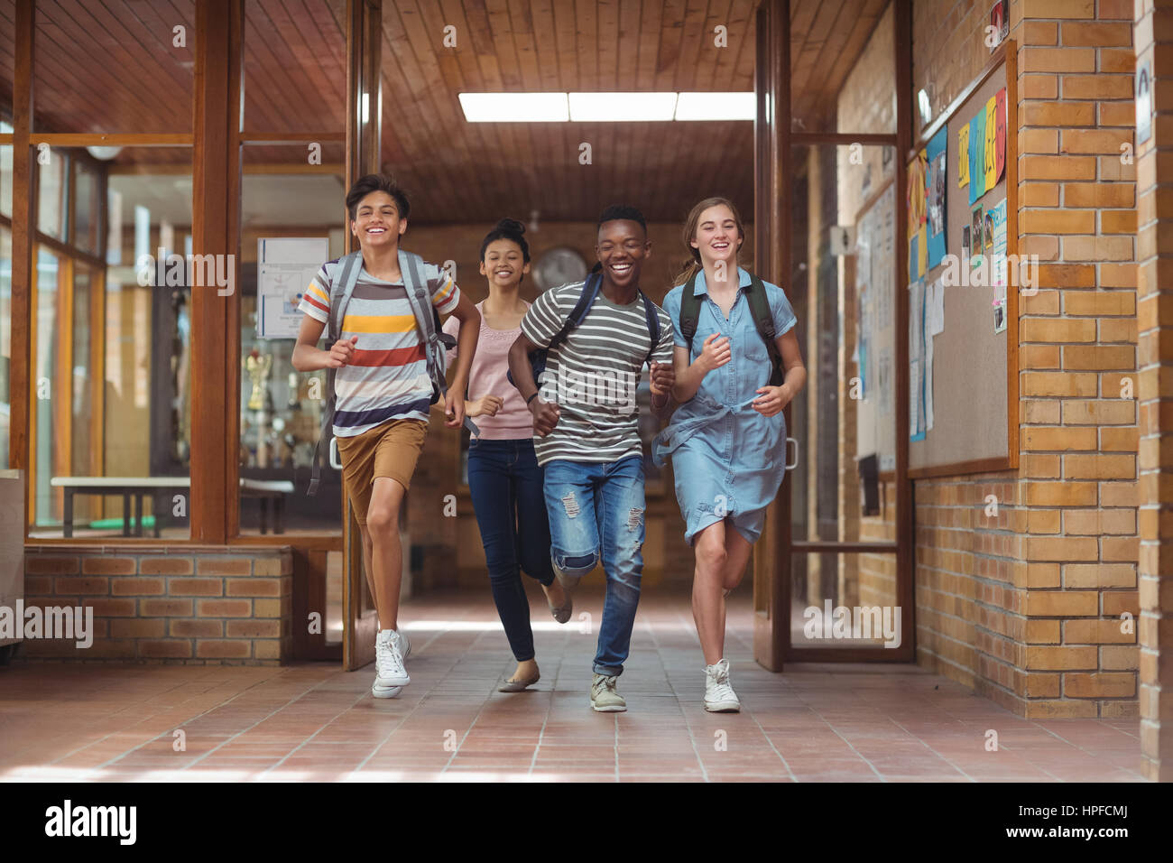 Excited classmates running in corridor at school Stock Photo - Alamy