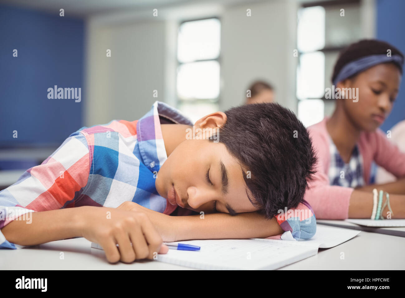 Tired schoolboy sleeping in classroom at school Stock Photo - Alamy