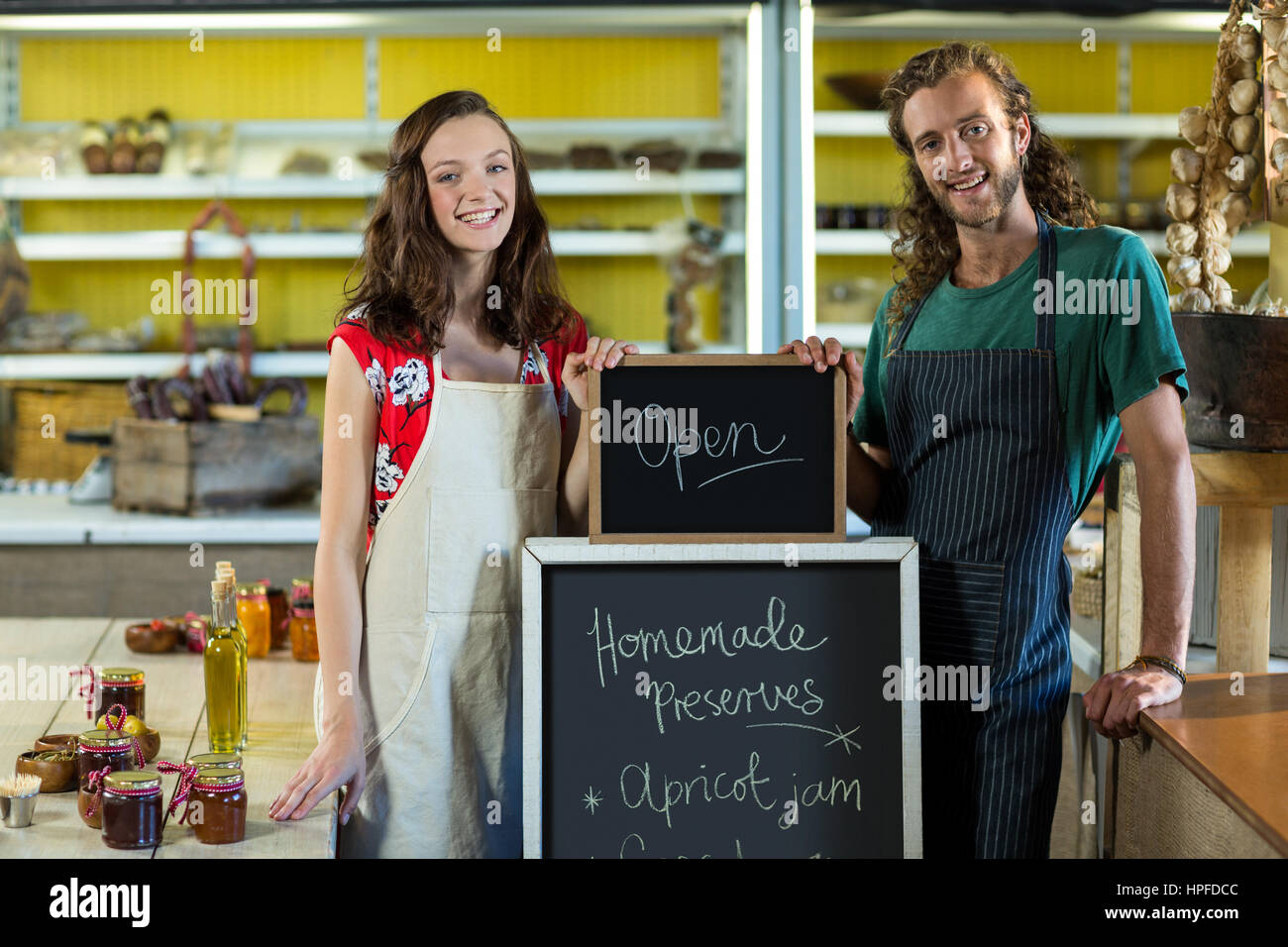 Shop assistants holding open sign board at grocery shop Stock Photo