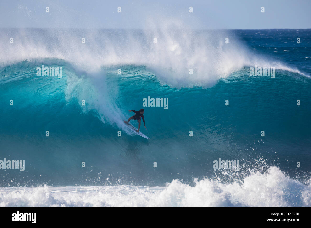 A surfing riding a wave at Pipeline on the North Shore of Oahu. Stock Photo