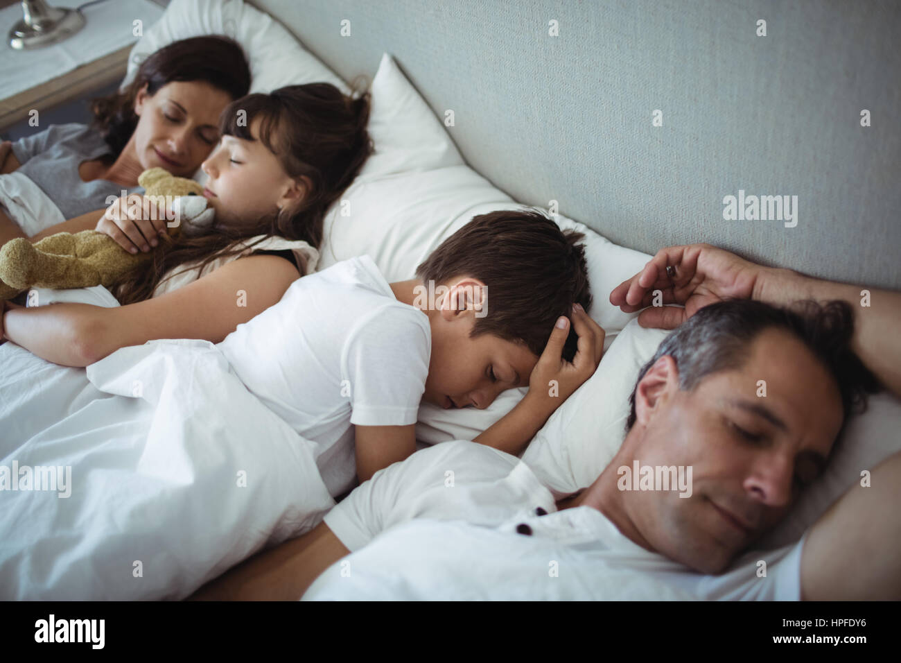 parents-and-kids-sleeping-on-bed-at-home-stock-photo-alamy