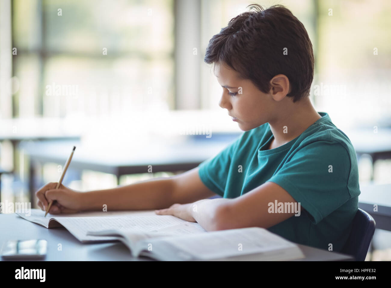 Attentive schoolboy studying in classroom at school Stock Photo - Alamy