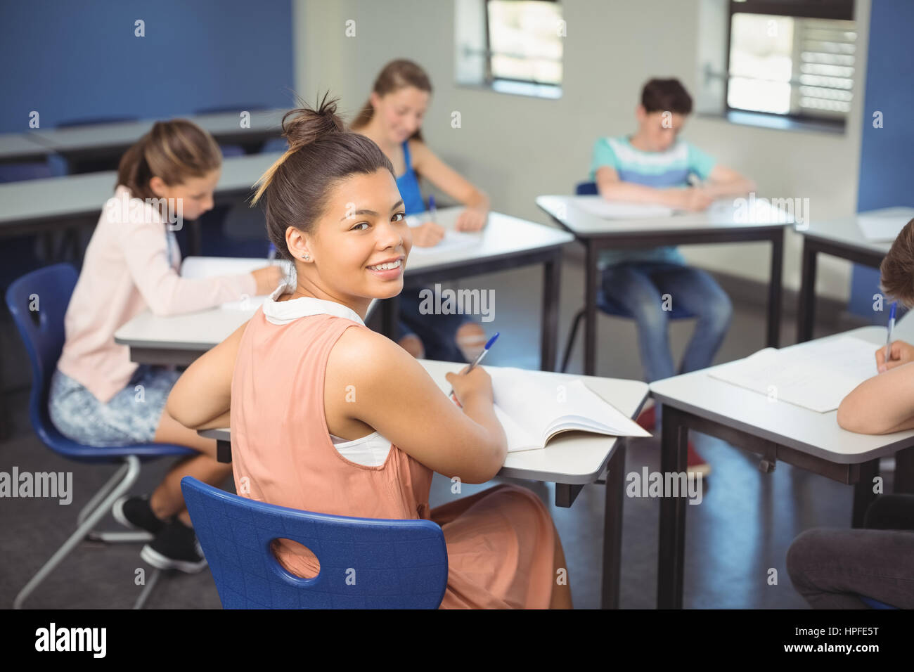 Portrait of schoolgirl sitting at desk in classroom Stock Photo - Alamy