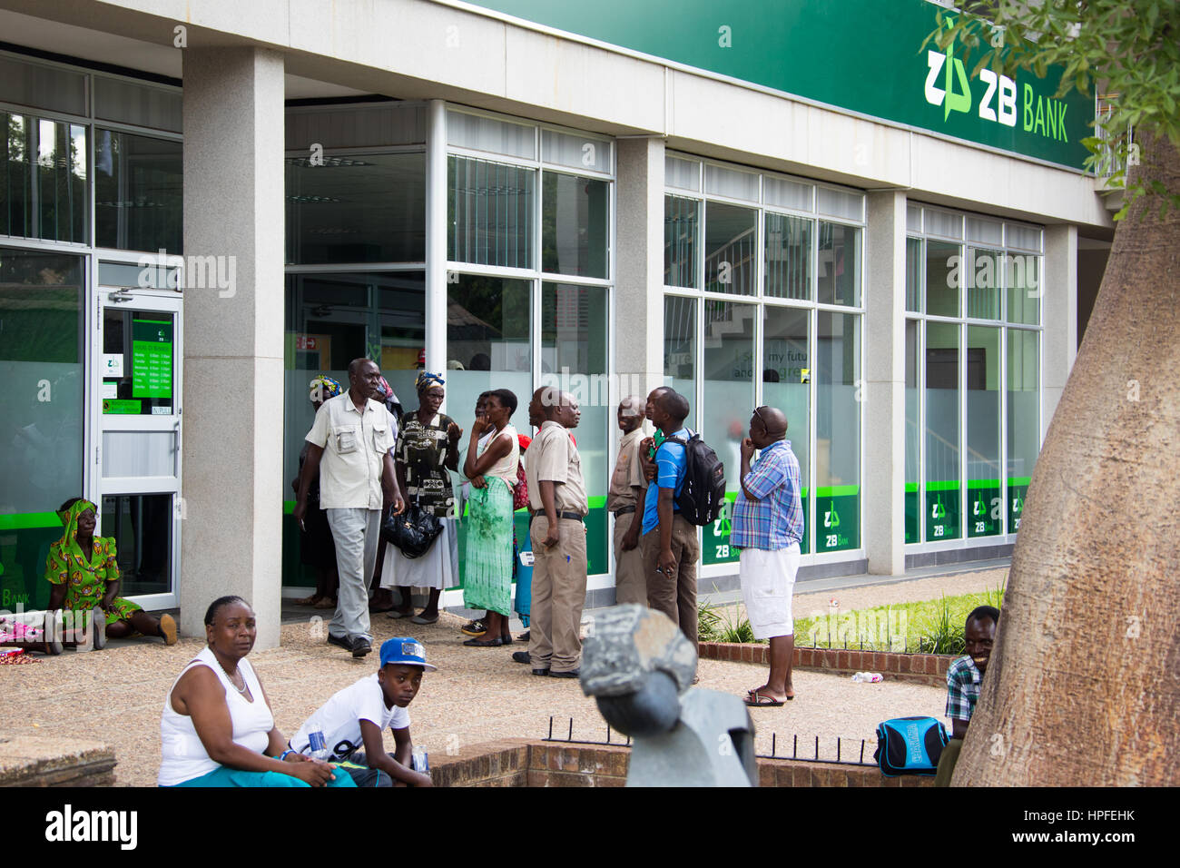 Line to draw money outside ZB Bank, Victoria Falls, Zimbabwe Stock Photo