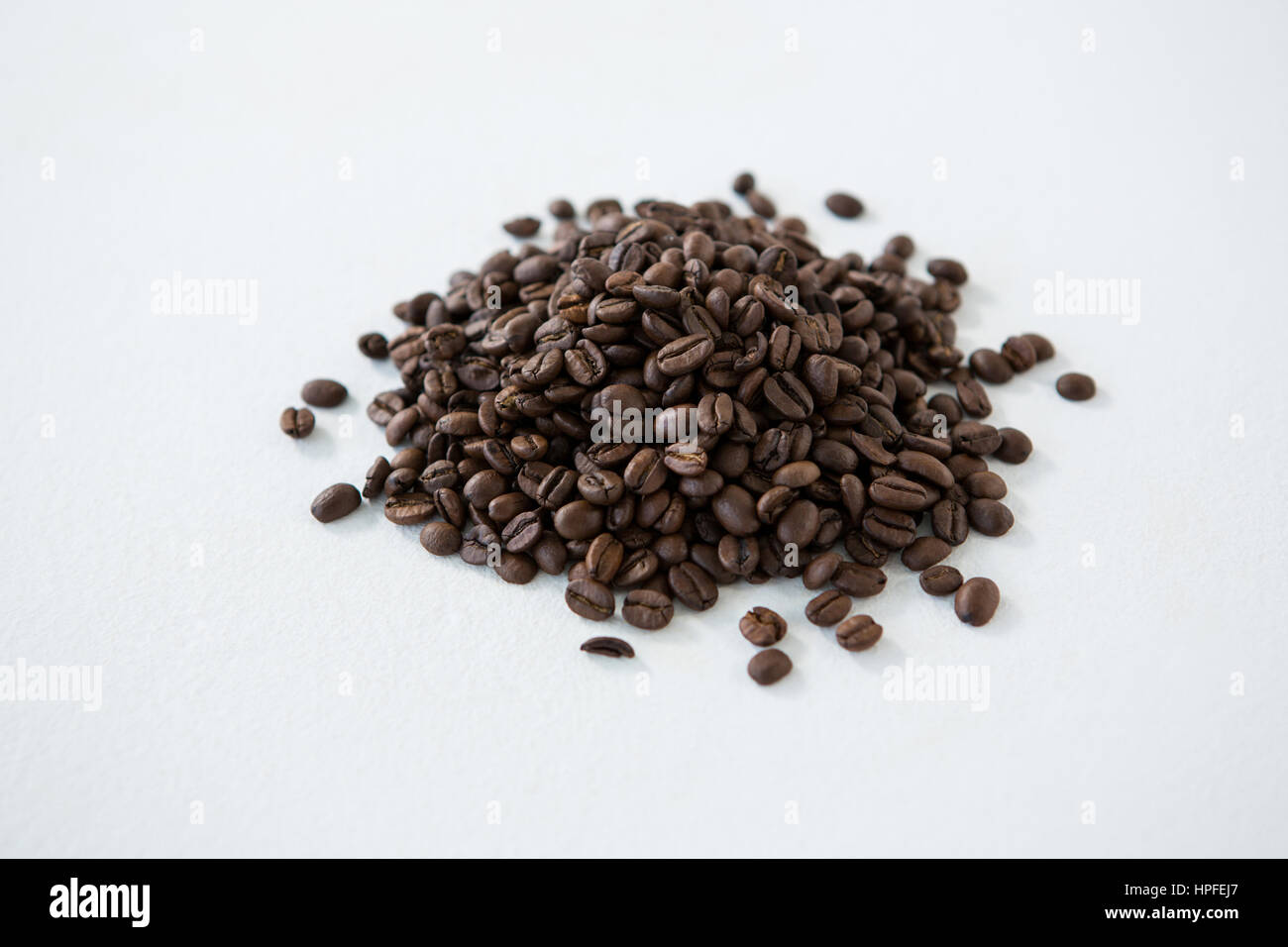 Pile of roasted coffee beans on white background Stock Photo - Alamy