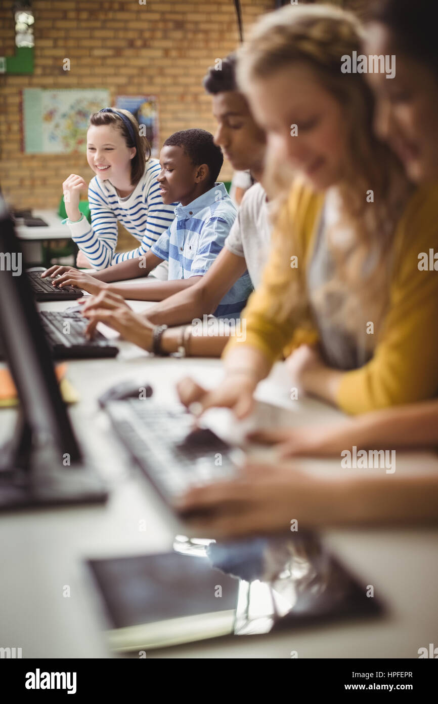 Smiling students studying in computer classroom at school Stock Photo ...