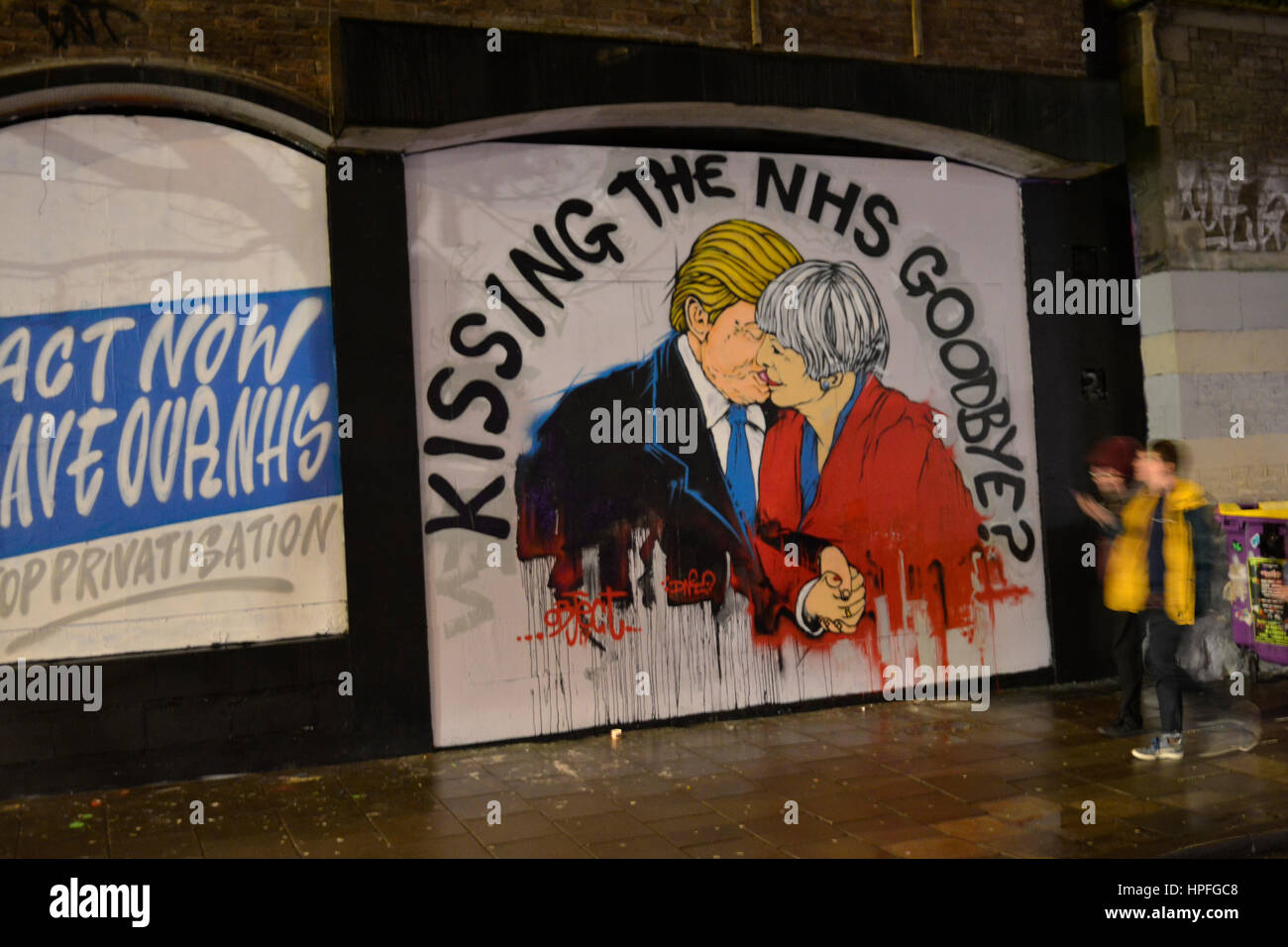Bristol, UK. 21st Feb, 2017. A passer- by stops to look at a new mural which has appeared in Stokes Croft in Bristol, showing US.President Donald Trump and UK Prime Minister Theresa May. with the words above.KISSING THE N.H.S GOODBYE. A previous mural in the same place Last Year showed Donald Trump and Boris Johnson in an Embrace. Credit: Robert Timoney/Alamy Live News Stock Photo