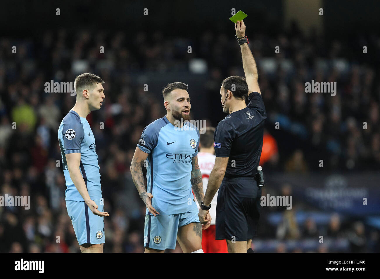 Manchester, UK. 21st Feb, 2017. Nicolas Otamendi of Manchester City is shown a yellow card by referee Antonio Mateu Lahoz during the UEFA Champions League Round of 16 first leg match between Manchester City and AS Monaco at the Etihad Stadium on February 21st 2017 in Manchester, England. Credit: PHC Images/Alamy Live News Stock Photo