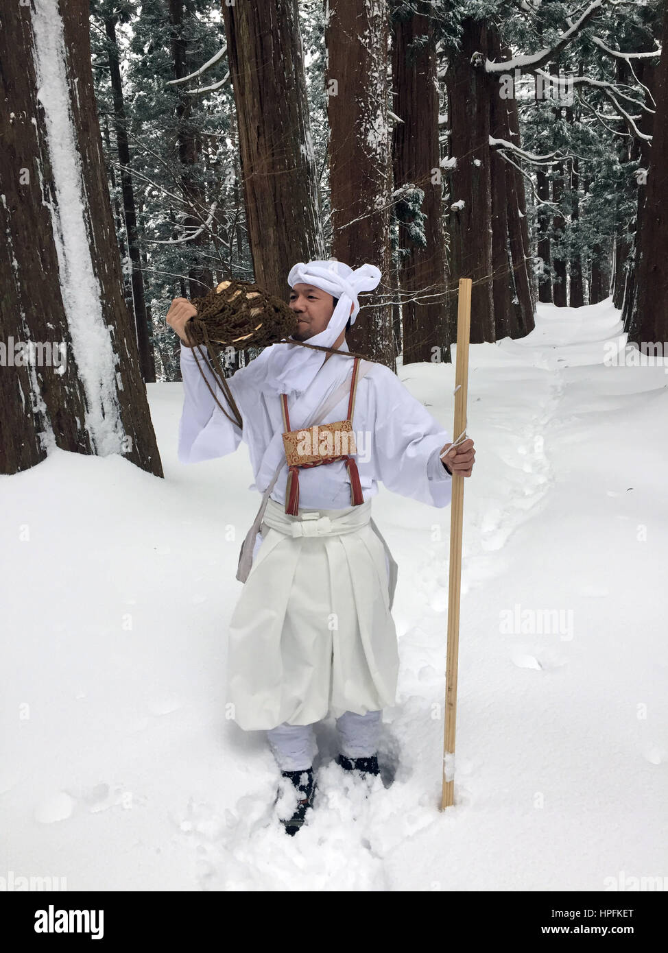 The Japanese Yamabushi mountain ascetic Takehiro Miura blows a conch shell horn in a snow-covered forest in the Yamagata Province, Japan, 15 February 2017. Monks and members of the laity have retreated into the mountains in the area to live a life immersed in ascetic rituals and prayer for some 1300 years. Photo: Lars Nicolaysen/dpa Stock Photo