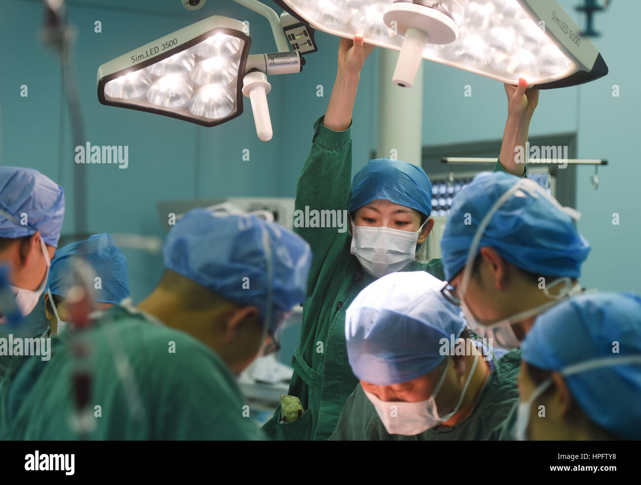 Fuzhou, China's Fujian Province. 22nd Feb, 2017. Nurse Wang Jieting adjusts a surgical lamp during an operation for Tong Xiaoyu (anonym) at the provincial maternal and child health care hospital in Fuzhou, southeast China's Fujian Province, Feb. 22, 2017. The two-year-old girl of She ethnic group received a nephroblastoma resection surgery at the hospital on Wednesday. Paediatrics doctors here perform thousands of surgeries every year. Credit: Song Weiwei/Xinhua/Alamy Live News Stock Photo