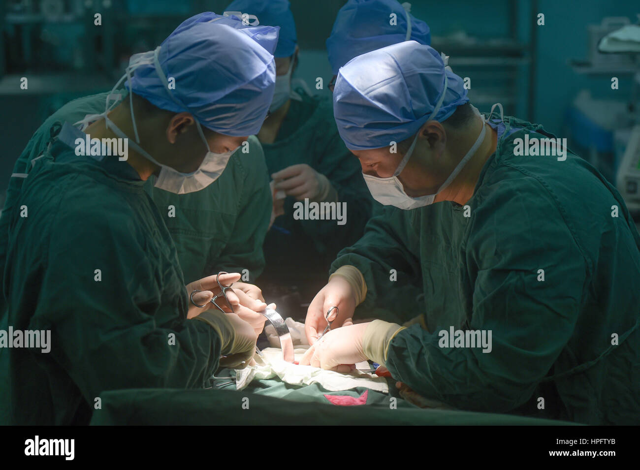 Fuzhou, China's Fujian Province. 22nd Feb, 2017. Doctor Wu Dianming (R) and his colleagues perform an operation for Tong Xiaoyu (anonym) at the provincial maternal and child health care hospital in Fuzhou, southeast China's Fujian Province, Feb. 22, 2017. The two-year-old girl of She ethnic group received a nephroblastoma resection surgery at the hospital on Wednesday. Paediatrics doctors here perform thousands of surgeries every year. Credit: Song Weiwei/Xinhua/Alamy Live News Stock Photo