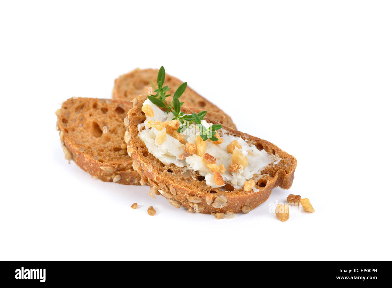 Hearty bread appetizers: Spicy German crackling lard on small rye bread slices garnished with thyme leaves Stock Photo