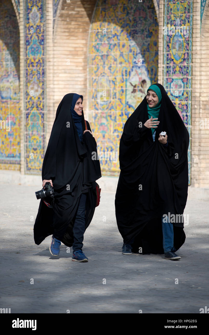 Two iranian young women in black veil with a camera at Golestan Palace, Tehran, Iran Stock Photo