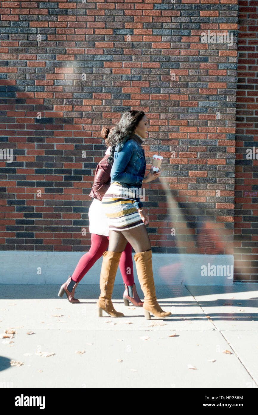 Two stylish young black woman walking with their coffee. St Paul Minnesota MN USA Stock Photo