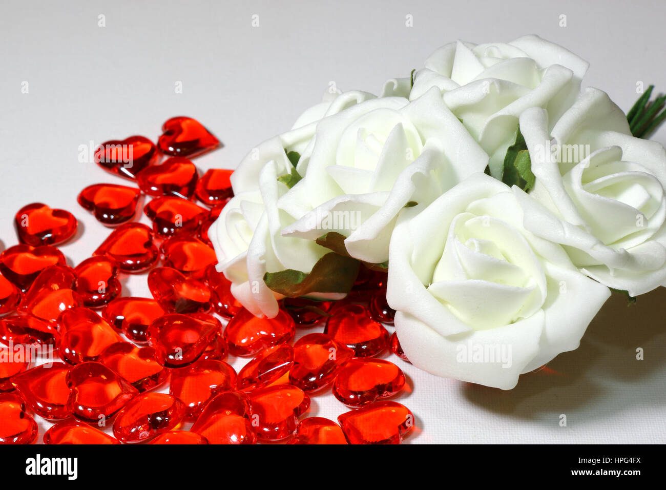 The Concept of a wedding with white roses, red petals and heart shapes ...