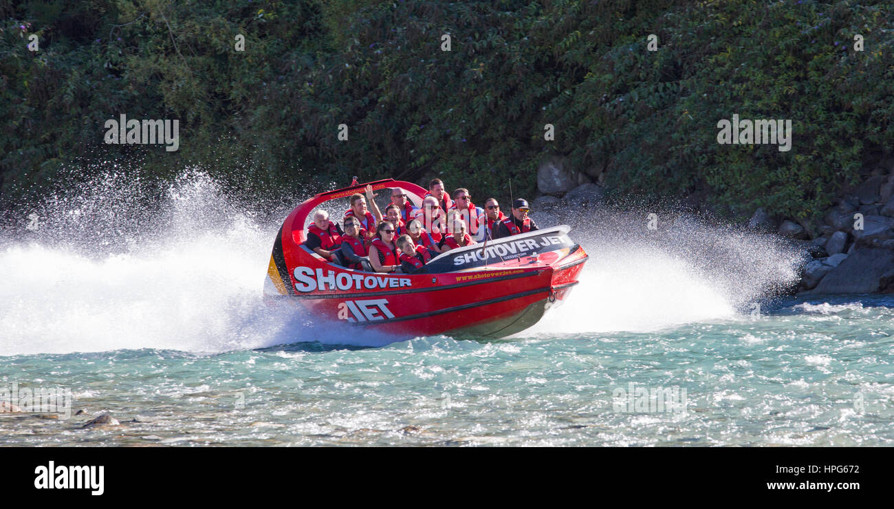 Queenstown, Otago, New Zealand. Shotover Jet boat speeding across the turquoise waters of the Shotover River. Stock Photo
