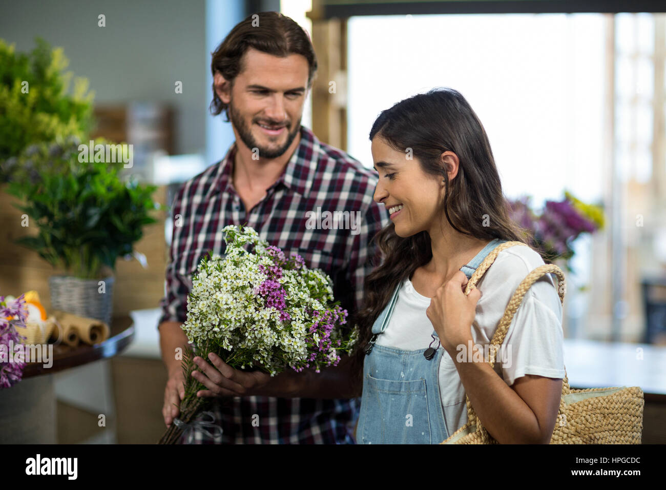Happy couple selecting flowers in the florist shop Stock Photo - Alamy
