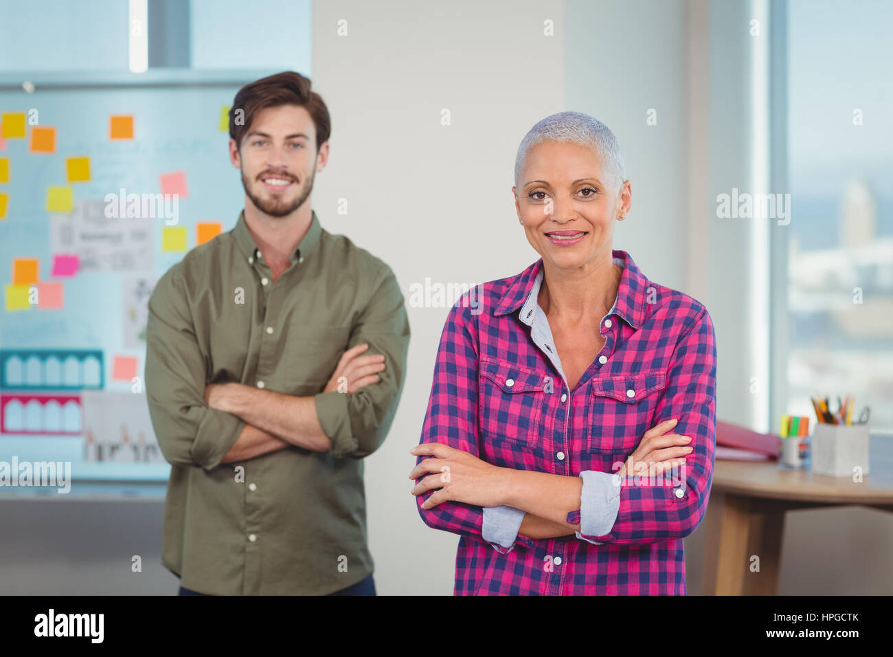 Portrait of executives standing with arms crossed in office Stock Photo ...