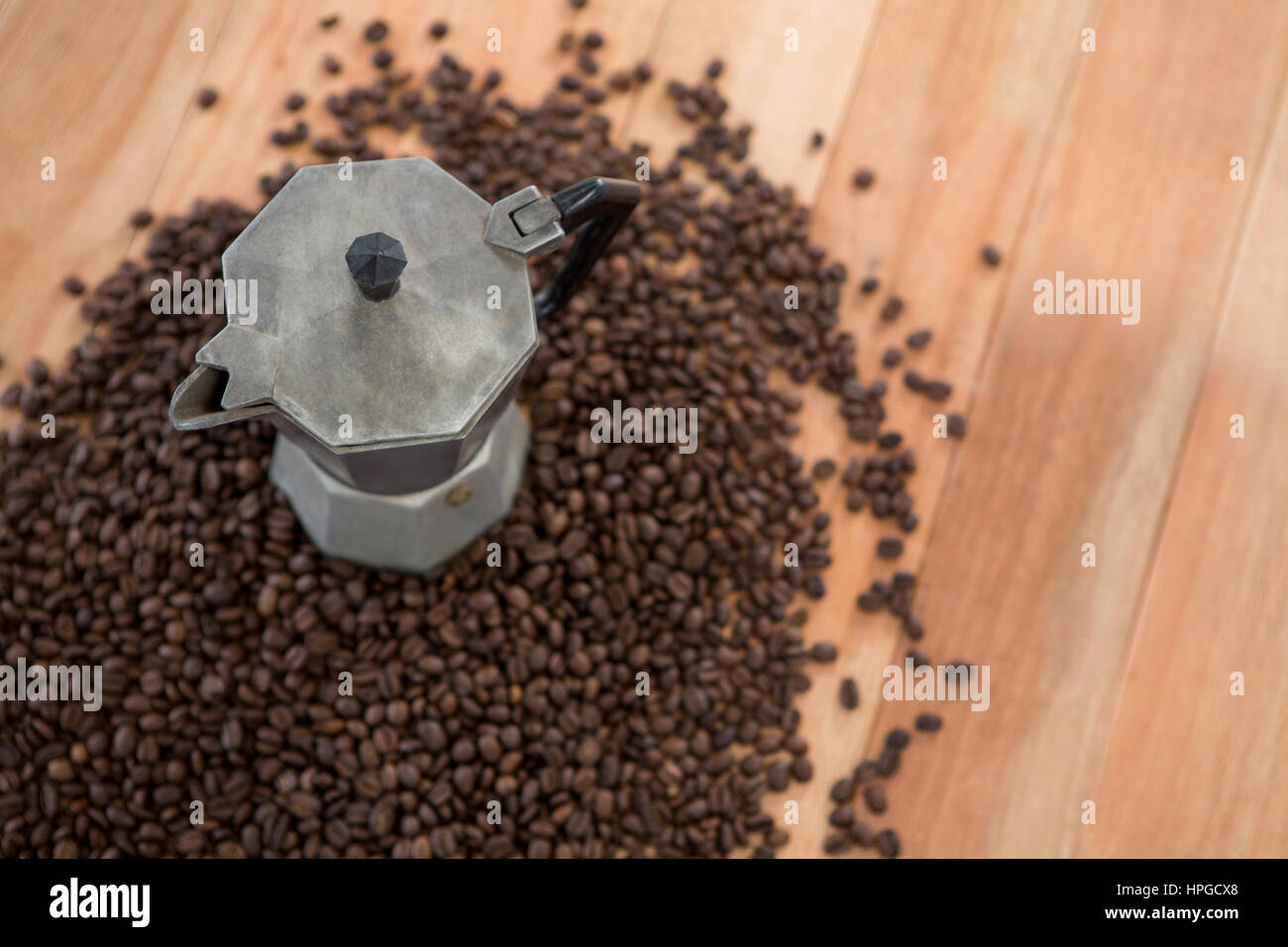 Coffee beans with metallic coffeemaker on wooden table Stock Photo