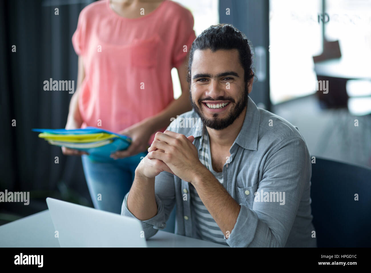 Portrait of smiling business executive sitting in office Stock Photo ...