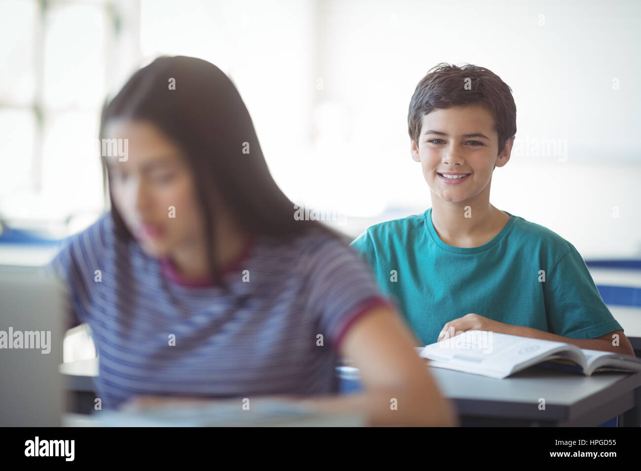 Portrait of happy schoolboy studying in classroom at school Stock Photo ...