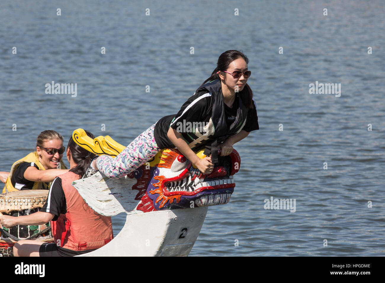 Woman preparing to grab a flag to signal winning a dragon boat race Stock Photo
