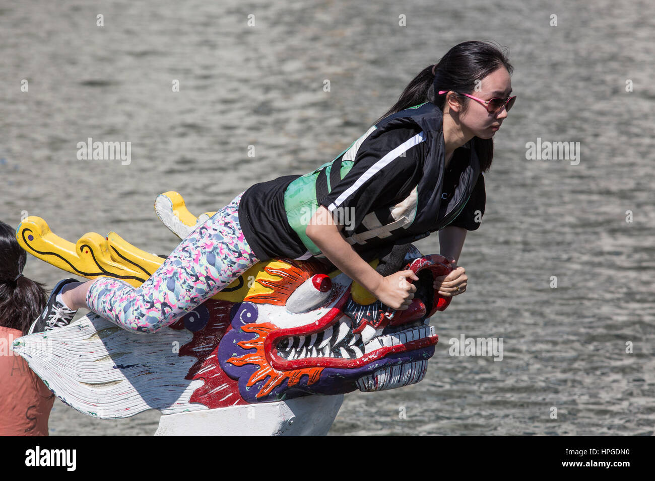 Woman preparing to grab a flag to signal winning a dragon boat race Stock Photo