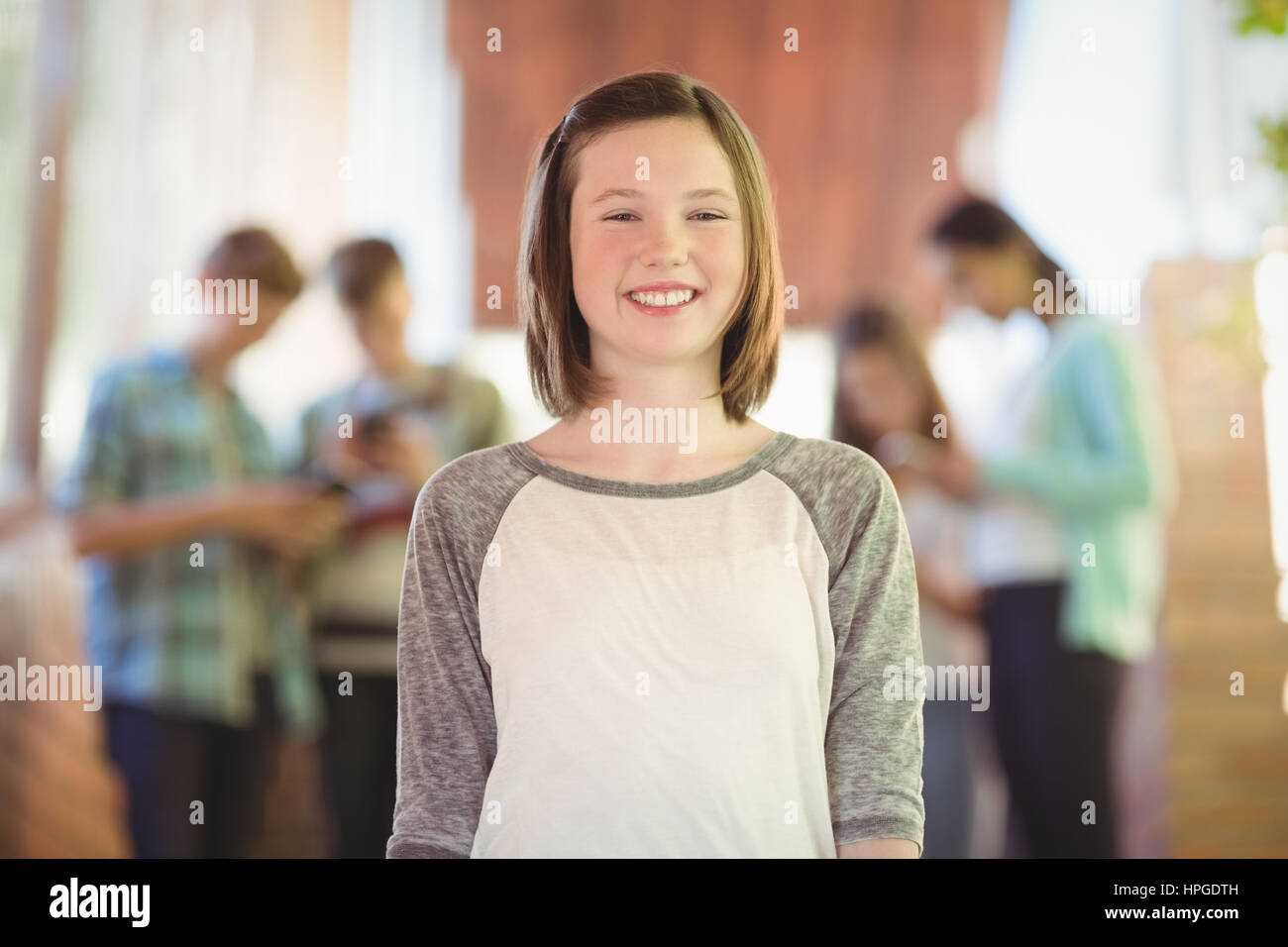 Portrait of smiling schoolgirl standing in corridor at school Stock ...