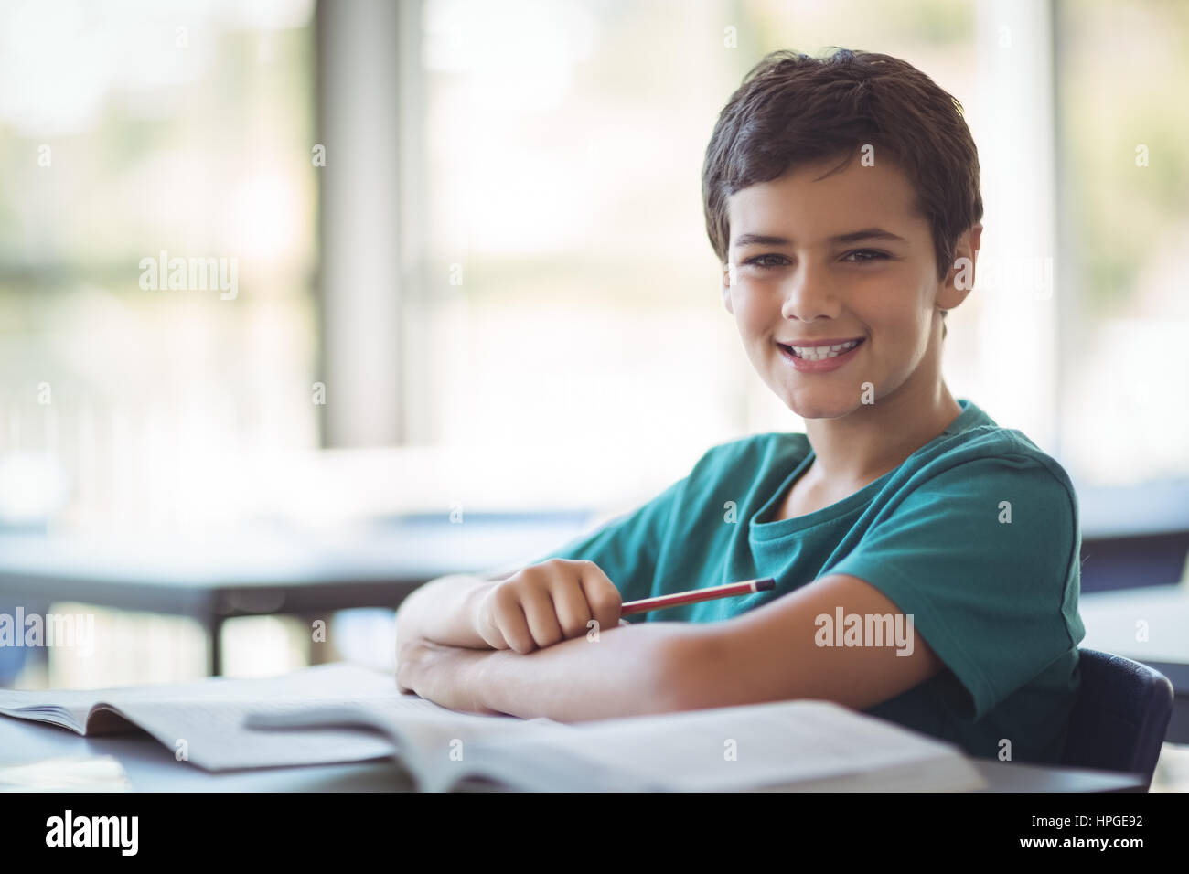 Portrait of happy schoolboy studying in classroom at school Stock Photo ...