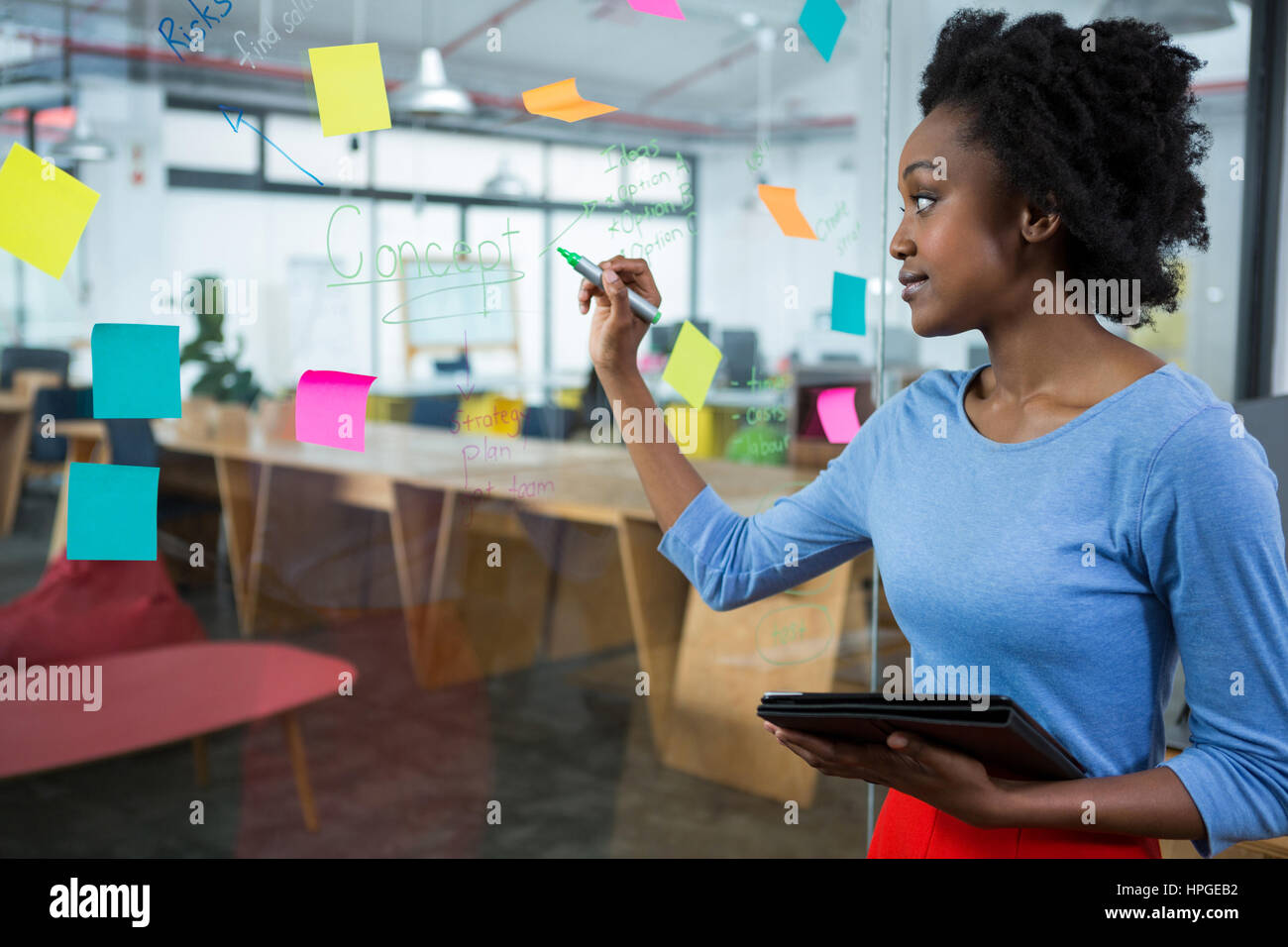 Female graphic designer writing on glass with marker Stock Photo - Alamy