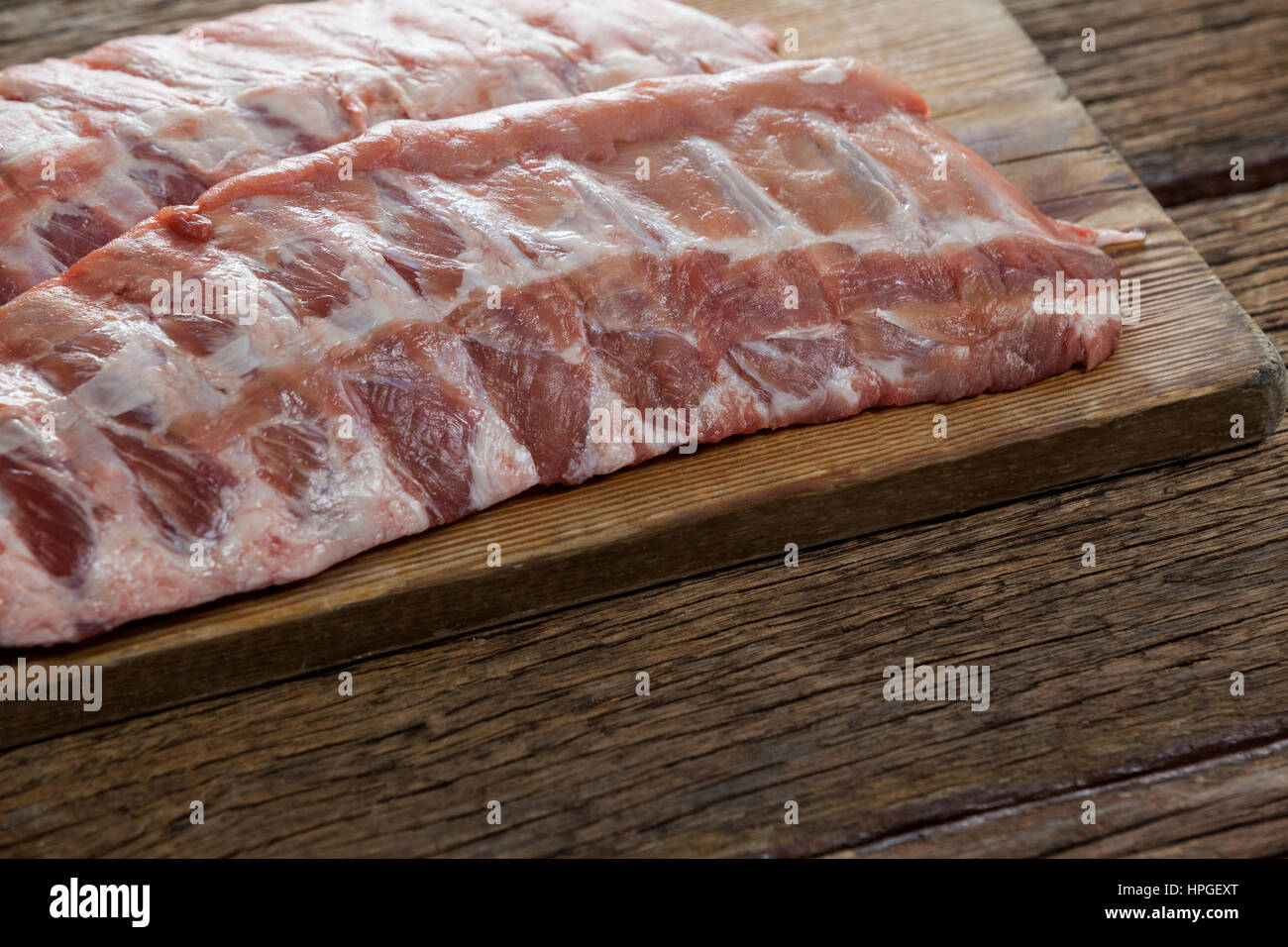 Beef ribs on wooden board against wooden background Stock Photo